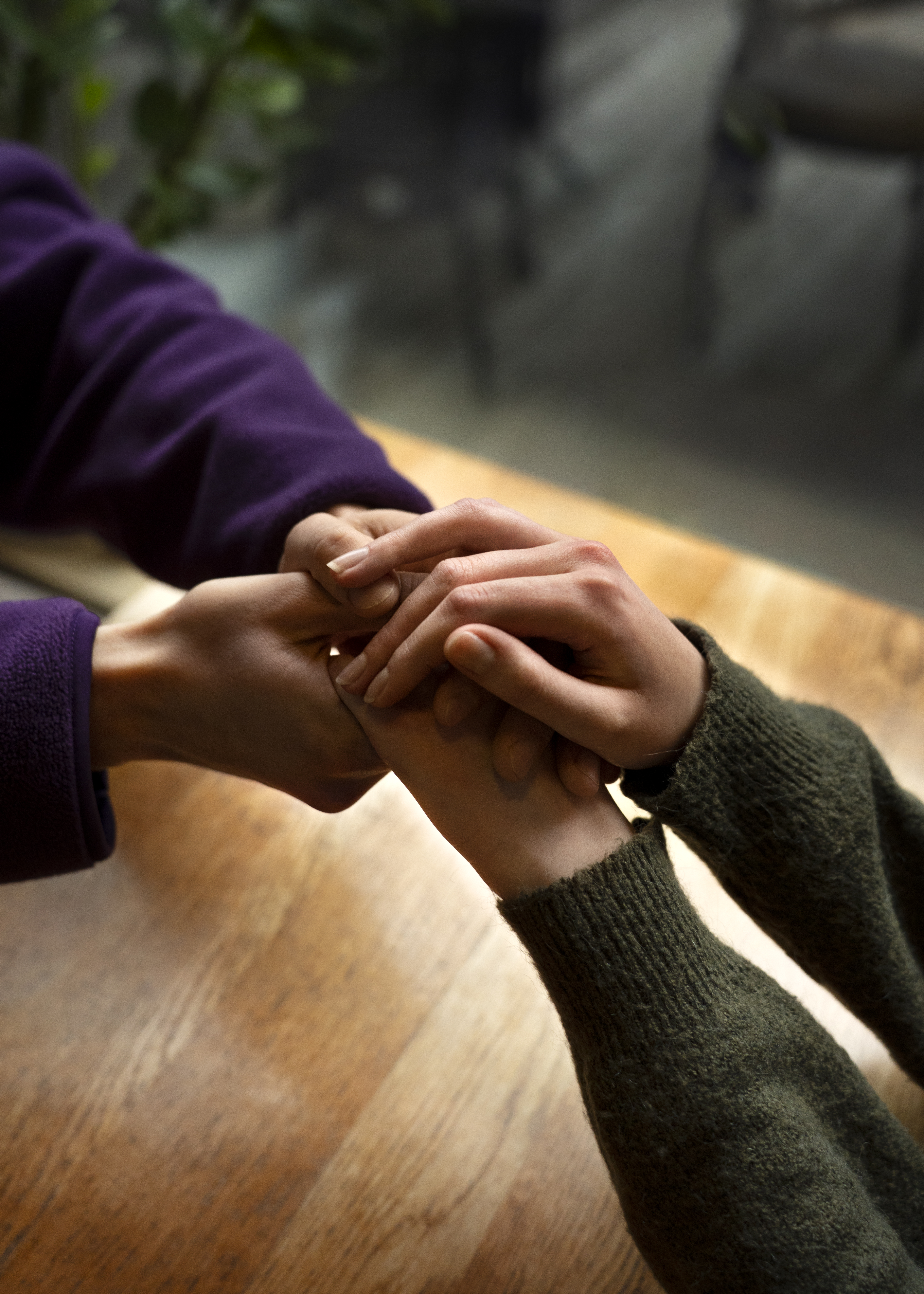 Close-up of hands holding each other in support