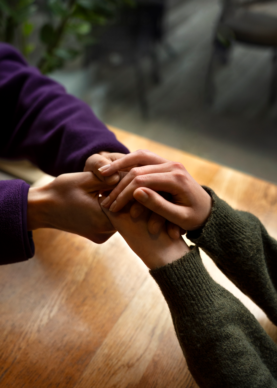Close-up of hands holding each other in support